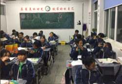 A photo of a group of students in a Chinese junior high school classroom, seated at desks
