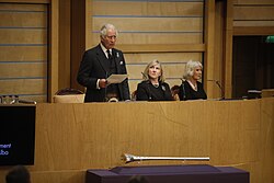 King Charles III addresses the chamber of the Scottish Parliament in September 2022. The parliament's Presiding Officer, Alison Johnstone, is seated in the centre and Queen Camilla to the far right.