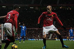 Evra (left) passing the ball to Gabriel Obertan in a match against Everton in the 2009–10 season