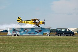 An unusual landing; a Piper J3C-65 Cub lands on a trailer as part of an airshow.