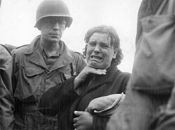 A Polish woman weeps as she tells American soldiers of her life as a slave labourer for the Nazis. She was liberated in Augsburg when the third-largest Bavarian city fell to the Americans (23 April 1945).