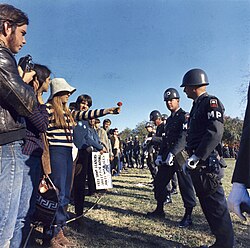 A demonstrator offers a flower to military police at an anti-Vietnam War protest, 1967.