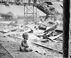 A baby sits in the remains of a Shanghai train station on 'Bloody Saturday', 1937