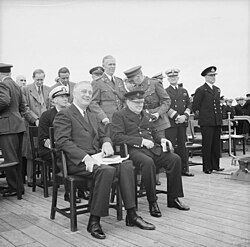 Marshall standing behind President Roosevelt and British prime minister Winston Churchill aboard the British battleship HMS Prince of Wales on 10 August 1941
