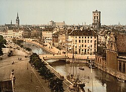 Slotsholmen canal, as seen from the Børsen building (c. 1900). In the background from left to right: Church of the Holy Ghost, Trinitatis Complex, St. Nicholas Church, and Holmen Church.