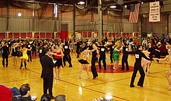 Intermediate level international-style Latin dancing at the 2006 MIT ballroom dance competition. A judge stands in the foreground.