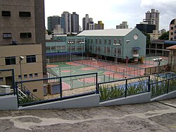 A sport club in Belo Horizonte, Brazil, showing various paved and painted surfaces for futsal, handball, basketball and volleyball, with two swimming pools in the foreground.