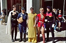 Photograph of five people standing together in costume