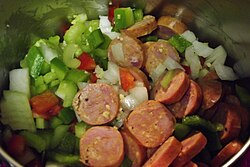 Ingredients for jambalaya in a pot beginning to cook