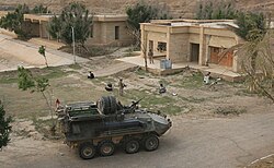 Marines from D Company, 3rd Light Armored Reconnaissance Battalion guard detainees prior to loading them into their vehicle