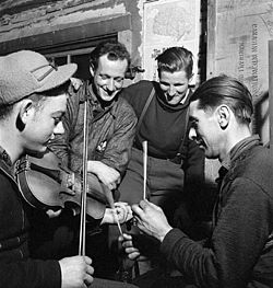 French-Canadian lumberjacks playing the fiddle, with sticks for percussion, in a lumber camp in 1943