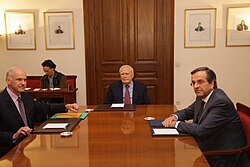 George Papandreou and Antonis Samaras with Karolos Papoulias, the President of Greece, on 6 November 2011 discussing the formation of a caretaker government.