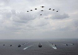 A mixed aircraft and ship formation of military vehicles during an exercise with USN and JASDF vehicles.