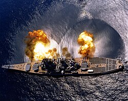 USS Iowa fires a full broadside of her nine 16-inch / 50 caliber and six 5-inch / 38 caliber guns during a target exercise.