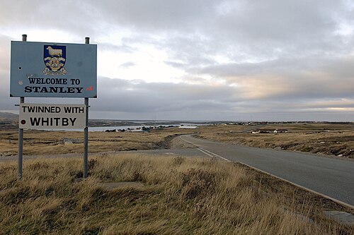 'Welcome to Stanley' sign, with Stanley in the background