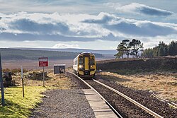 An Abellio ScotRail Class 158 (158720 "Inverness & Nairn Railway - 150 years") heads into Altnabreac station.