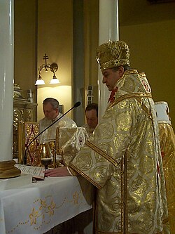 A bishop celebrating Divine Liturgy in a Greek Catholic church in Prešov, eastern Slovakia. Another bishop stands to his immediate right (white omophorion visible), and two married priests stand to the side (facing camera).