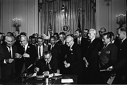 President Lyndon B. Johnson signs the 1964 Civil Rights Act at the White House on July 2, 1964, as Martin Luther King Jr. and others look on.