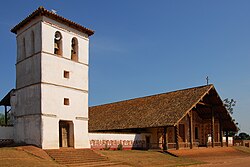 A church and stone bell-tower in three-quarter view (2009)