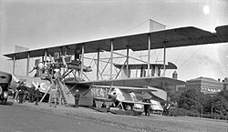 Curtiss NC-4 flying boat after it completed the first crossing of the Atlantic in 1919, standing next to a fixed-wing heavier-than-air aircraft