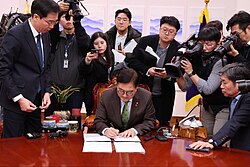 Speaker of the National Assembly Woo Won-shik signing the motion for impeachment