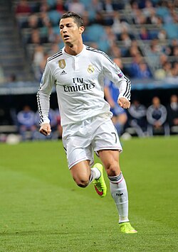 A man in a white shirt and shorts looking upwards.