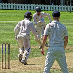 Batters attempting a run while a fielder awaits a throw.