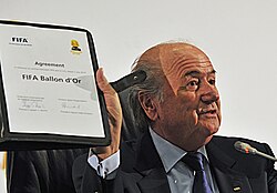 FIFA President Sepp Blatter holds up the agreement creating the FIFA Ballon d'Or in Johannesburg in July 2010.