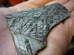 A polished and chemically etched piece of an iron meteorite, believed to be similar in composition to the Earth's metallic core, showing individual crystals of the iron-nickel alloy (Widmanstatten pattern)