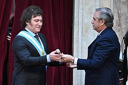 Milei receiving the presidential scepter from outgoing president Alberto Fernández.