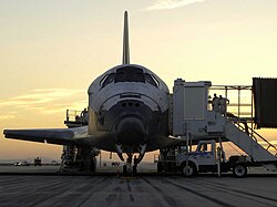 The Space Shuttle Discovery on the runway as ground crews work to get the crew out of the orbiter