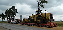 Mammoet Tii Hydraulic modular trailer attached to a Mercedes ballast tractor moving front end loader