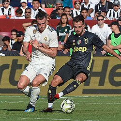 Bale (left) battling the ball with Juventus player Miralem Pjanić during a pre-season match in August 2018