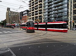 A dedicated right of way lane in Toronto. The tram on the left is about to enter a track operating in mixed traffic.