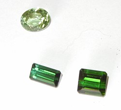 Two dark-green rectangular tourmaline stones and one oval tourmaline stone