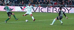 Brazilian striker Ronaldo (middle, in white) taking a shot at goal. A multi-functional forward, he has influenced a generation of strikers who followed.[5]