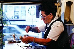 Enriqueta Gastelumendi [es], working on a carving in her home in Ushuaia