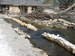 A row of sandbags behind the lower London Avenue Canal breach fails to keep water from flowing into neighborhood streets in early November 2005.