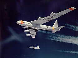 X-15 attached to its B-52 mother ship Balls 8 with a T-38 flying nearby