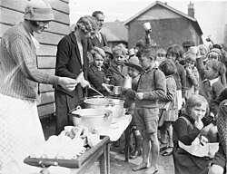 Schoolchildren line up for free issue of soup and a slice of bread in Belmore North Public School, Sydney, 1934
