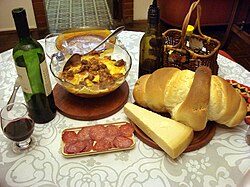 A typical meal in Rio Grande do Sul with wine, bread, cheese, and pasta with beef and salami