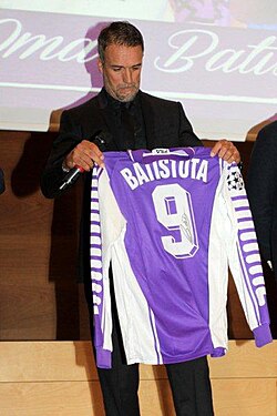Gabriel Batistuta holding his old number 9 Fiorentina jersey. The number most associated with the position, he was an out-and-out striker.