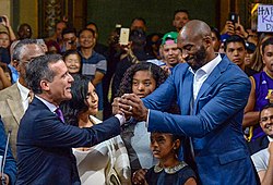Bryant holding Los Angeles Mayor Eric Garcetti's hand during a 2016 ceremony in which the city of Los Angeles declared August 24 as "Kobe Bryant Day"