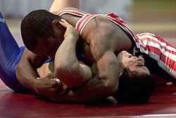 The wrestler on top working to secure a fall in this freestyle wrestling match