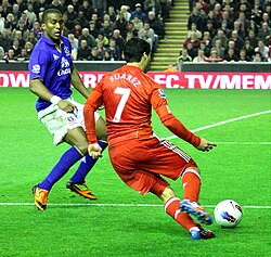 Suárez, in action for Liverpool, takes on Sylvain Distin of Everton during the Merseyside Derby in 2012