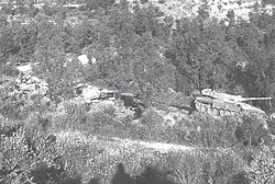 An Israeli tank advances past destroyed Syrian tanks during the Battle of Jezzine