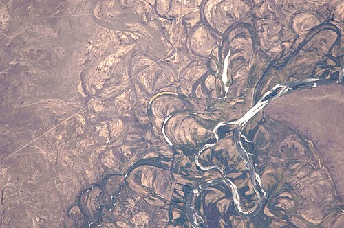 Meander scars, oxbow lakes, and abandoned meanders in the broad flood plain of the Río Negro near Colonia Josefa. 2010 photo from ISS