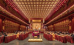 Buddhist monastics and laypeople chanting sutras in the Buddha Tooth Relic Temple, Singapore