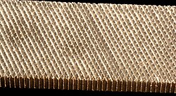 A file is an abrasive surface like this one that allows machinists to remove small, imprecise amounts of metal.
