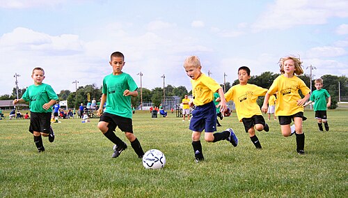 Sport in childhood. Association football, shown above, is a team sport which also provides opportunities to nurture physical fitness and social interaction skills.